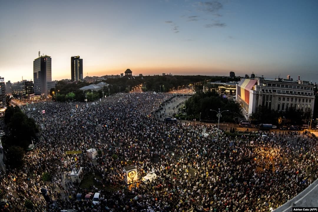 Mulțime adunată în Piața Victoriei, București, la apus.